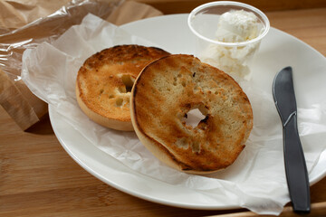 A view of a plate of bagels and cream cheese.