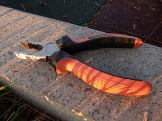 Red-Edged Pliers on a Stone Surface: A Precision Tool for Cutting