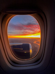 Sunrise over the horizon seen through the window of a holiday jet