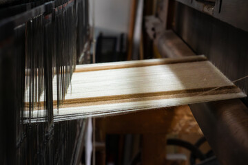 Close-up of a loom weaving colorful fabric