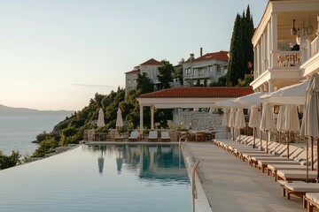 Luxurious poolside view at a serene seaside resort during a golden sunset in a tranquil coastal setting