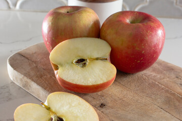 A view of some Fuji apples, featuring one that is halved.