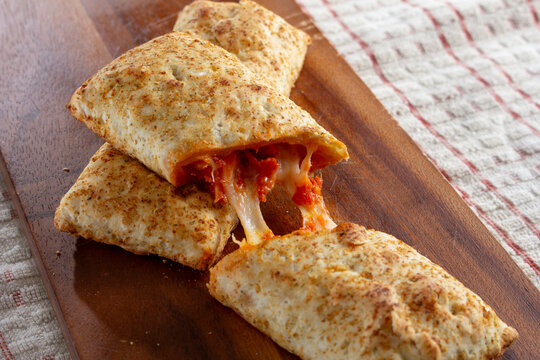 A view of a sliced microwavable pizza pocket.