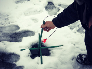 Winter sport recreational ice fishing hole in ice