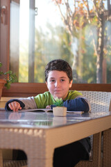 Happy little boy doing homework.