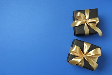 Beautiful gift boxes tied with bows on color background 