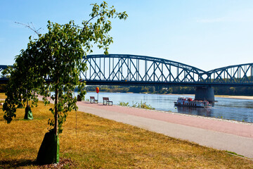 Statek z turystami przepływający pod mostem, tworzące się łachy wiślane, Toruń, Polska