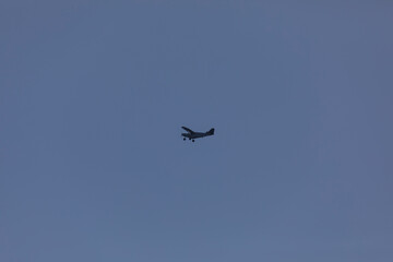 A small plane flies over the Fervenza reservoir in Dumbria with a blue sky