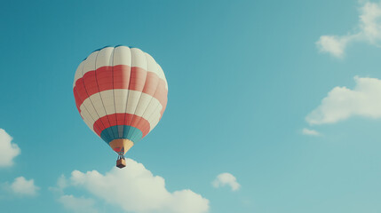 Fototapeta premium A colorful hot air balloon ascends against a bright blue sky with fluffy white clouds.