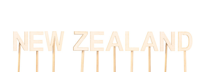Country name New Zealand in wooden letters on white-transparent background.