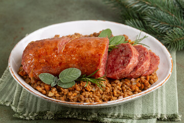 Traditional cotechino con lenticchie or pork sausage with Lentils cooked with vegetables. Traditional italian Festive meal..