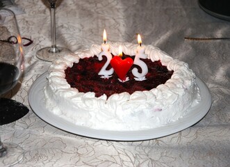 Birthday cake decorated with candle with chocolate and whipped cream.