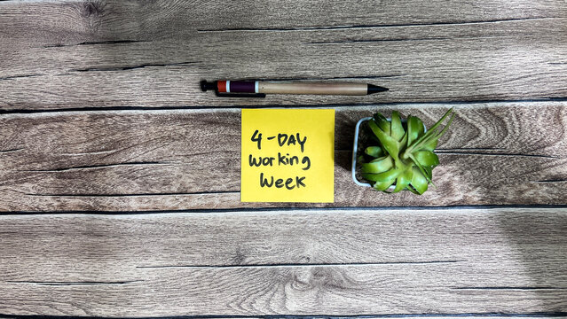 Concept of 4 day working week write on sticky notes isolated on Wooden Table.