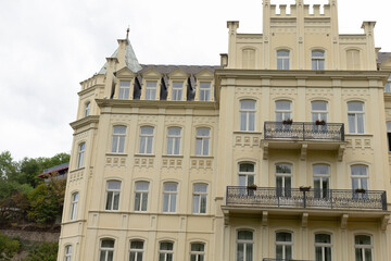 Fototapeta premium A yellow historical building that prominently features elegant balconies and multiple inviting windows