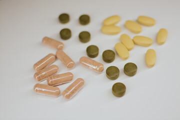 Multi-colored tablets of different shapes with different medical effects on a white background 