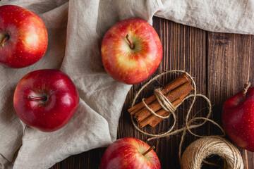Red apples on a wooden background with cinnamon