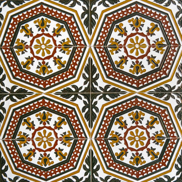 Fragment of building wall with glazed ceramic tiles, embossed vintage Mudejar, close up. Traditional ornate Spanish architecture. Abstract background, textured ornate pattern for design or backdrop.