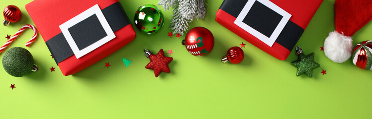 Christmas Red gift boxes, baubles, candy canes, stars, and a Santa hat on a green background. Xmas banner design.