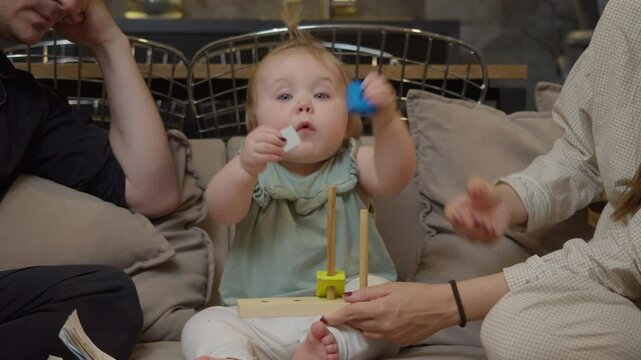 Young child sorts blocks and learns about shape and texture of objects thanks to toys that help develop their intelligence and spatial reasoning skills.