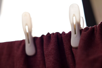 Una toma de cerca de una franela o camisa con varios ganchos de ropa en una cuerda