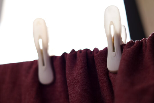 Una toma de cerca de una franela o camisa con varios ganchos de ropa en una cuerda