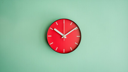 Red wall clock on mint green wall