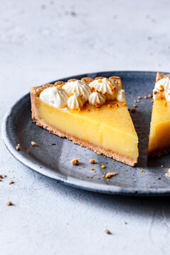 Lemon tart on a plaster surface with piped whipped cream-17