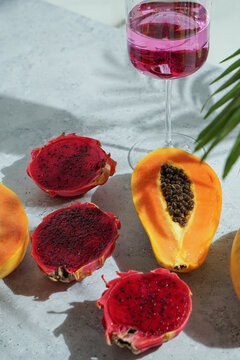 glass with cocktail, dragon fruit, also known as pitaya, cut open pink magenta-colored flesh with tiny black seeds, tropical fruits
