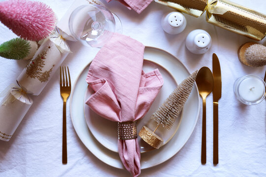 Christmas Dinner Table Setting in Modern Pink, White and Gold Theme, Close Up.