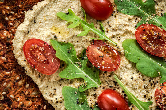 Vegetable flat bread with spread, tomatoes and arugula