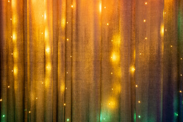 abstract colorful background with stars. Christmas garland decoration hanging on the curtain at home. Christmas lights illumination 