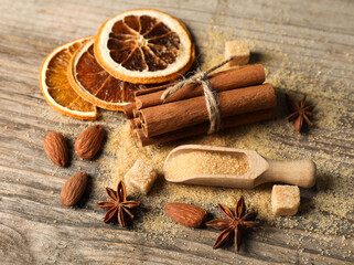 Different spices and dried orange slices on wooden table, above view. Christmas season