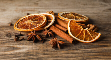 Different spices and dried orange slices on wooden table, closeup. Christmas season