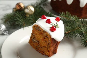 Piece of traditional Christmas cake decorated with red currants and rosemary on table, closeup