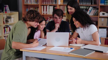 Diverse group of high school young students working together using and looking at laptop in library. Happy Generation Z classmates multiracial friends studying sitting with computer on class project - Powered by Adobe