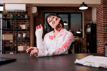 Portrait of burnout woman with tired expression limping on office desk chair, looking like zombie...
