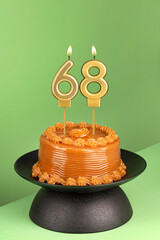Number 68 birthday candle on a green background - Delicious cake with dulce de leche
