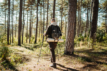 Young caucasian man hiking or trekking through the forest	