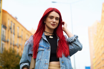 Young woman with red hair strolls down a vibrant city street in autumn