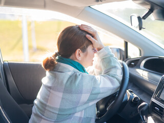 Caucasian woman cries while driving. 