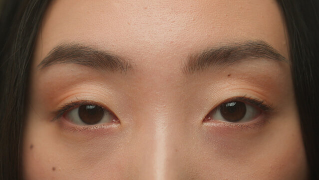 Macro extreme close up Asian woman female dark eyes face details korean japanese chinese girl model eyeball iris eye open eyesight gaze vision blink eyelashes skin care medical surgery beauty health
