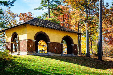 Obraz premium Empty park pavilion in the morning sunlight among fall leaves.