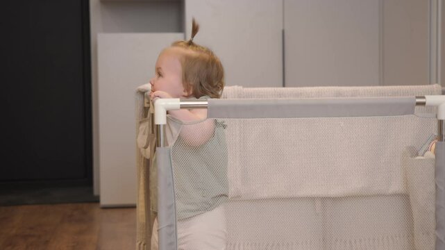 little girl was waiting for her parents to come and pick her up from playpen. When they finally arrived, they picked her up and carried her away. Happy mom and dad.