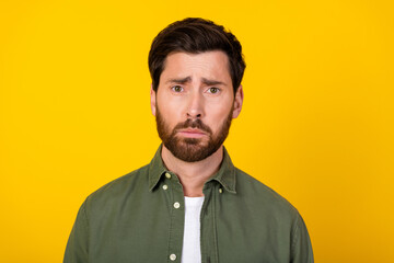 Portrait of nice young man sullen face wear khaki shirt isolated on yellow color background