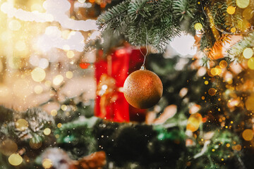  Christmas Ornament on Tree with gold glitter and sparkling bokeh.Golden shiny ball on christmas...