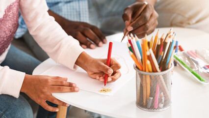 Creative hobbies. Closeup of African American child and her granddad drawing with color pencils at home, panorama