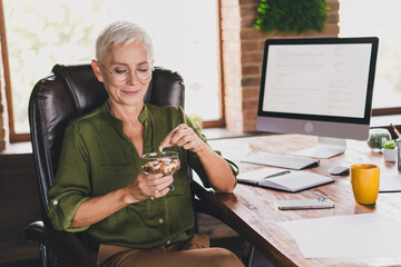 Photo of successful charming lady dressed shirt eyewear eat healthy snack workstation loft interior...