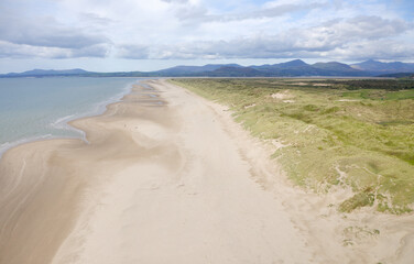Harlech Beach on Ceredigion Bay, Gwynedd, west Wales. View northwest along sand beach and dunes to mountains of Snowdonia. Aerial