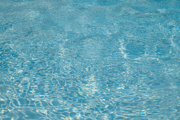Blue water reflection. Blue pool waves. Swimming pool. Water surface. Blue water texture. Close up blue water surface. Textured background.