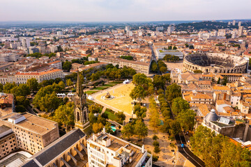 Aerial view of historical area of French city of Nimes overlooking restored antique Roman amphitheatre on sunny autumn day